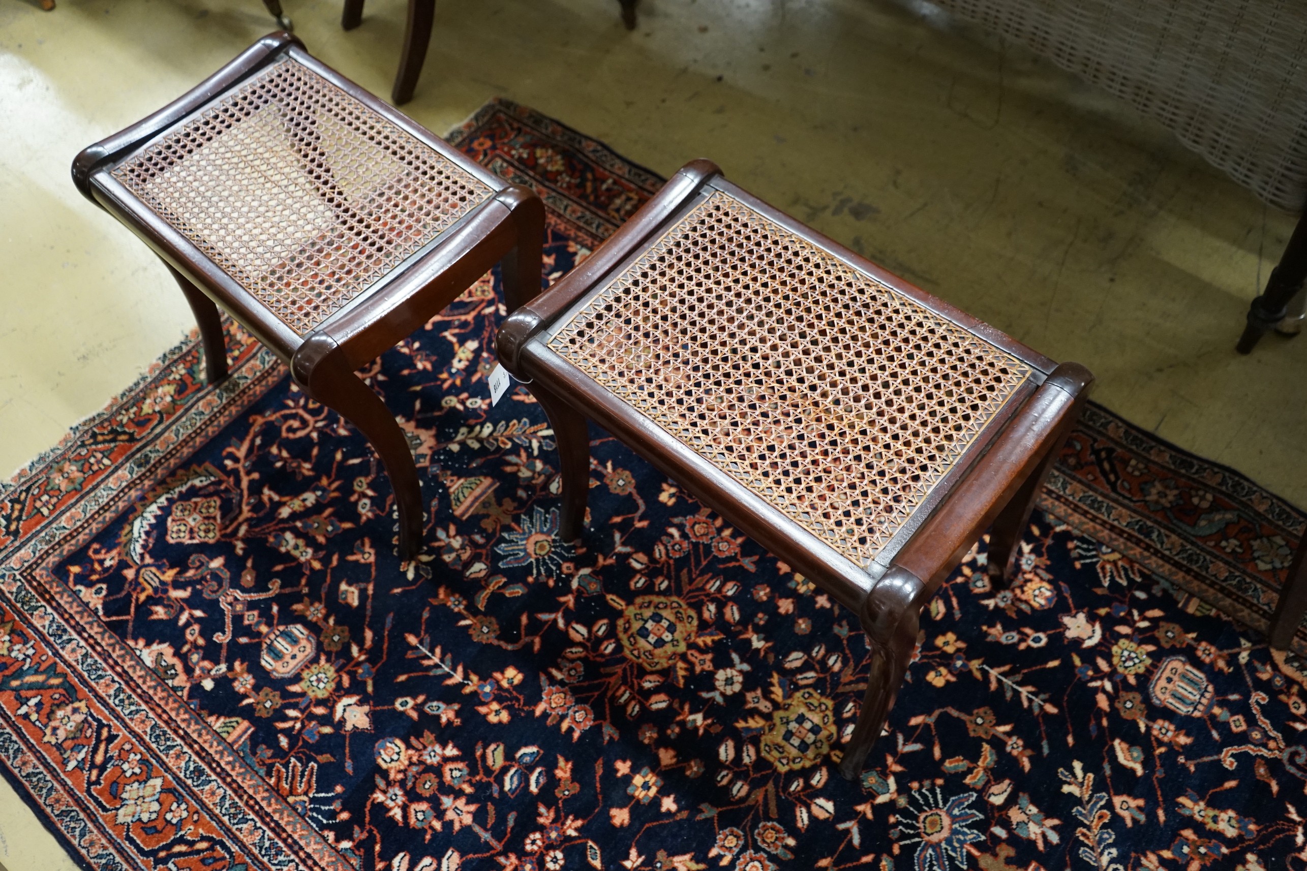 A pair of Regency style cane seat stools